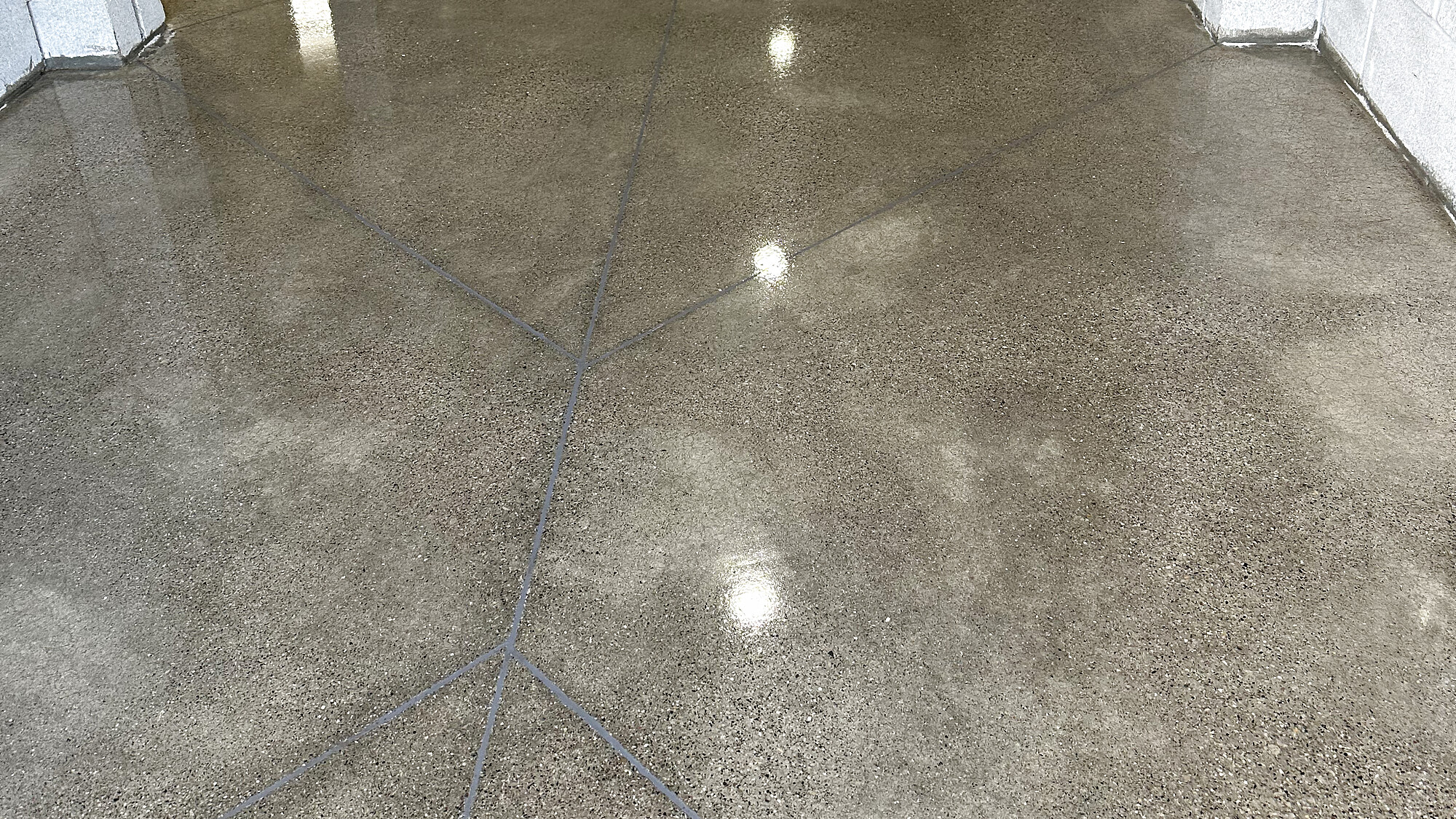High-gloss polished concrete floor with rich aggregate detail and warm light reflections