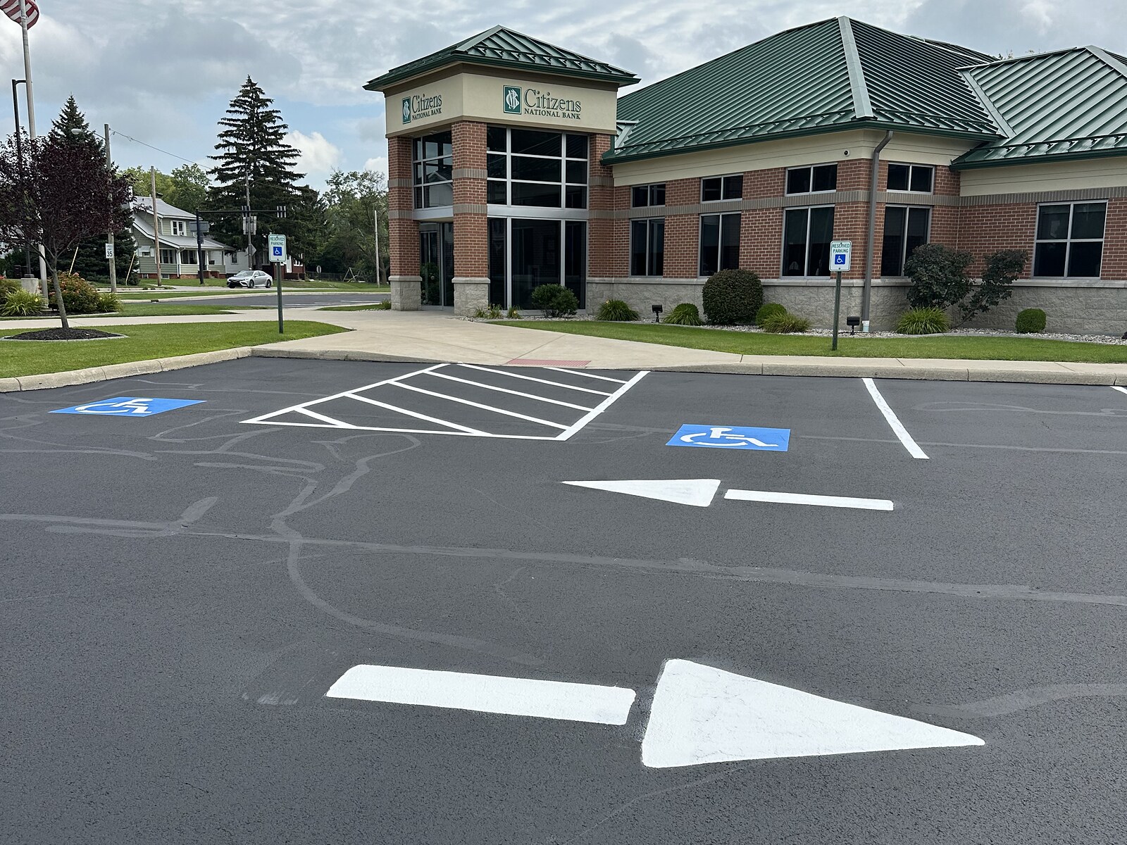 Sealcoated parking lot with ADA stalls and directional arrows at Citizens National Bank