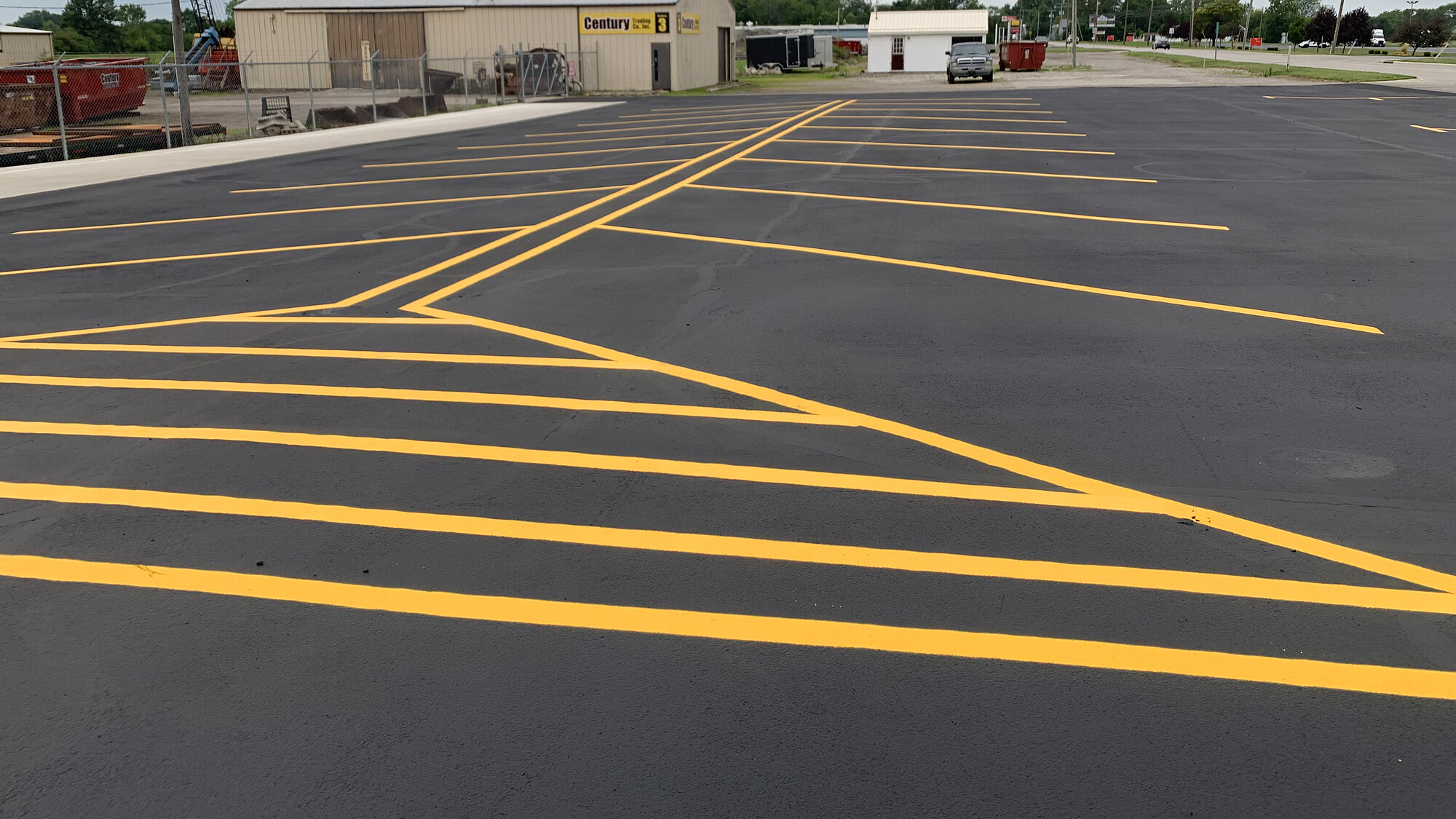 Fresh yellow line striping pattern on a sealcoated commercial parking lot at Century