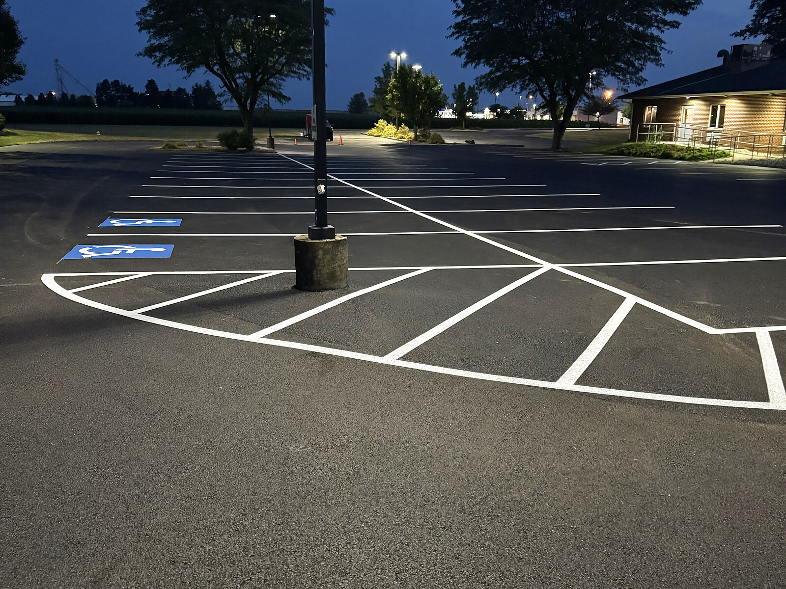 Crisp white line striping at dusk under parking lot lights